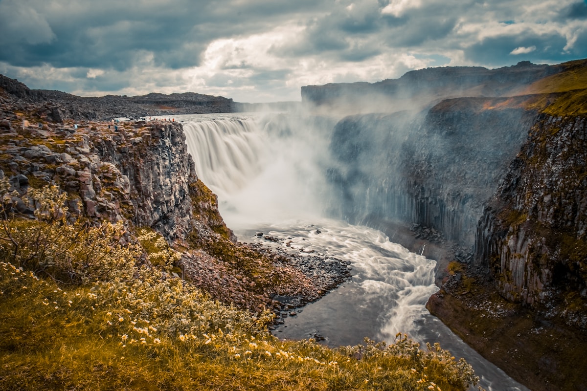 Dettifoss waterfall in full force, cascading into a canyon in northeast Iceland under dramatic skies