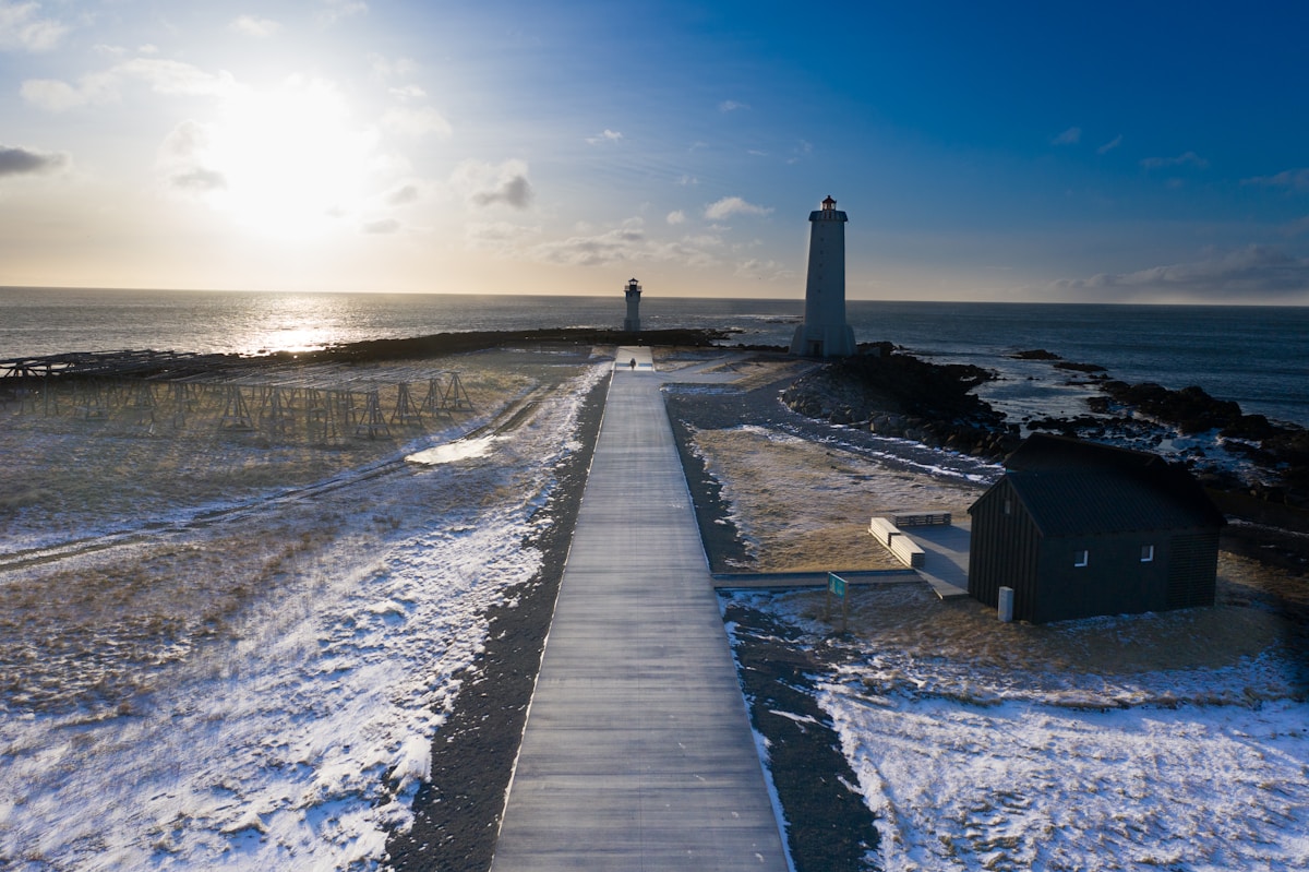 White lighthouse near the shoreline with calm water, Akranes, west Iceland