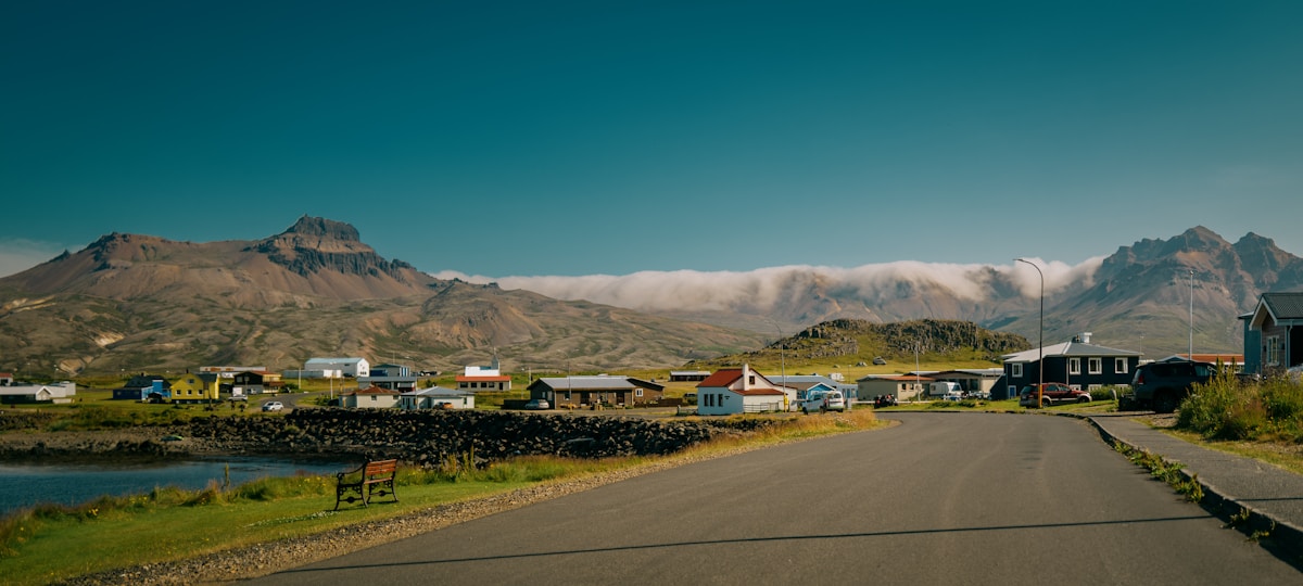 Icelandic coastal village with colourful houses and dramatic mountains in clear summer light