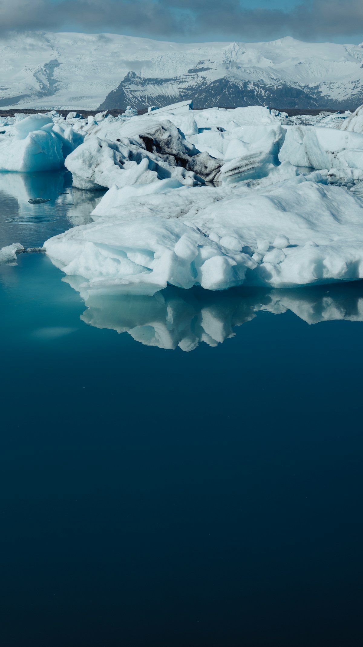 Icebergs floating in Jökulsárlón Glacier Lagoon with snow-capped mountains, Höfn, Iceland