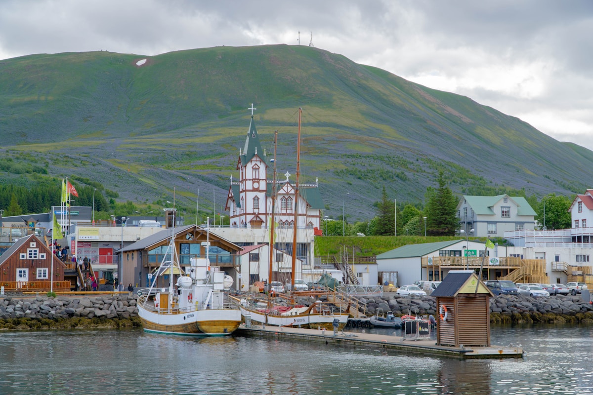 Boats moored in Húsavík harbour with mountains visible across Skjálfandi Bay, north Iceland