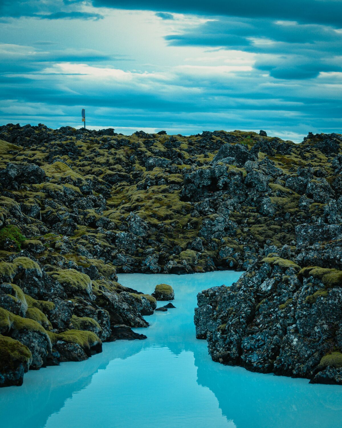 Milky-blue geothermal waters winding between moss-covered lava rocks at the Blue Lagoon, Iceland