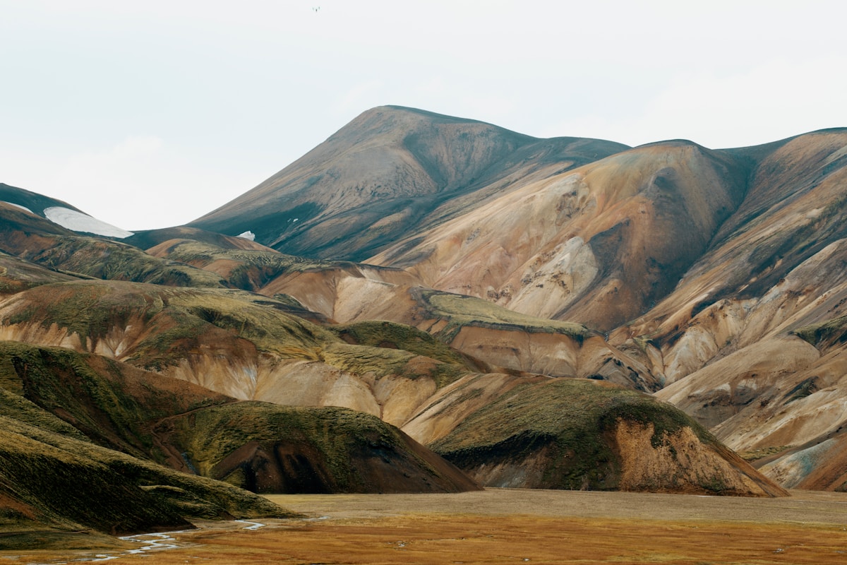 Multi-coloured rhyolite mountains of Landmannalaugar under pale sky, Iceland highlands