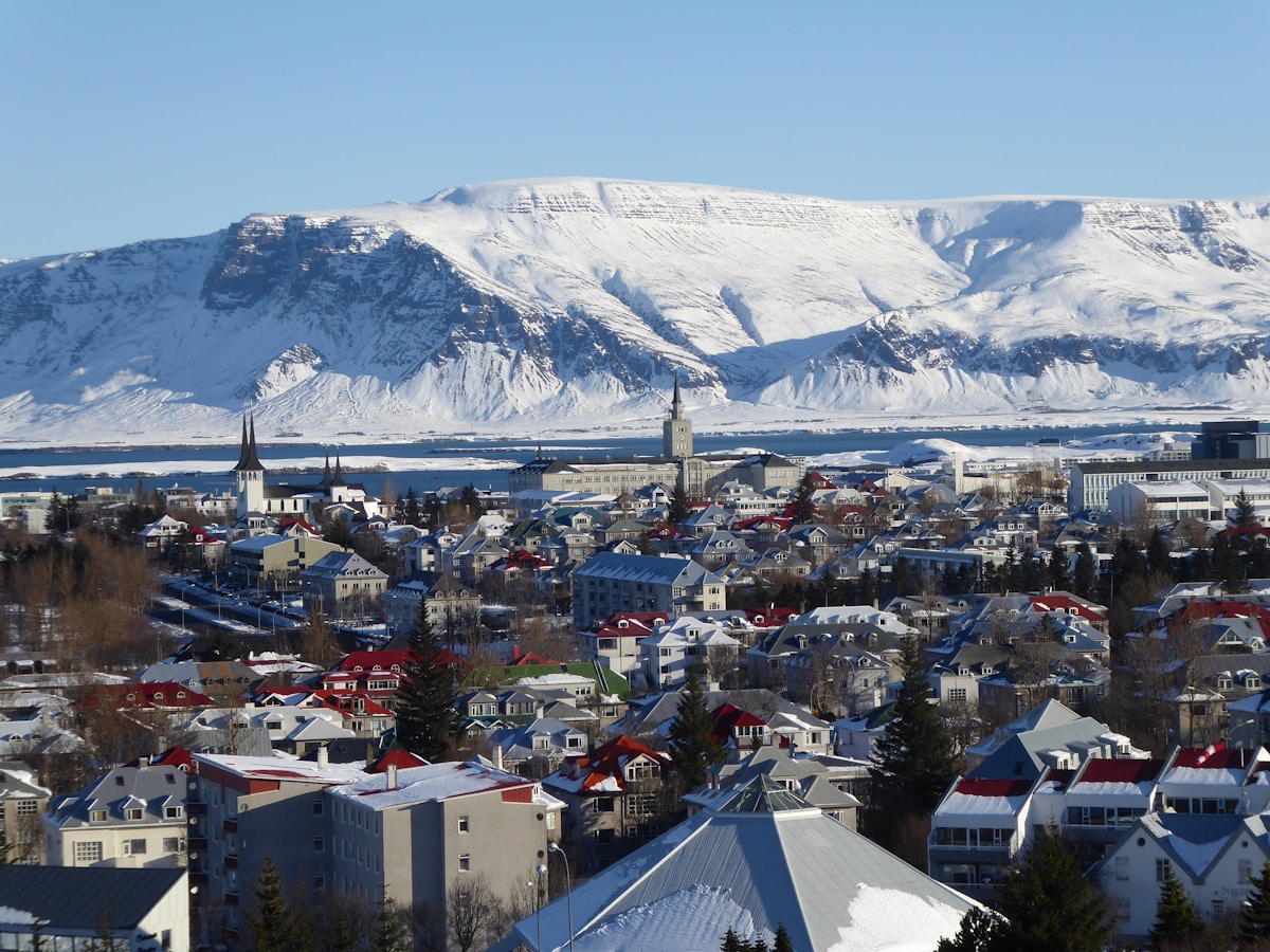 Winter aerial view of Reykjavík with colourful rooftops and snow-covered mountain backdrop, Iceland