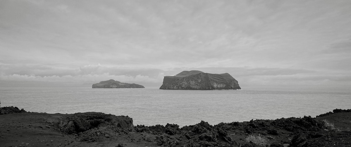Two volcanic islands rising from the Atlantic seen from rocky lava shore, Vestmannaeyjar, Iceland