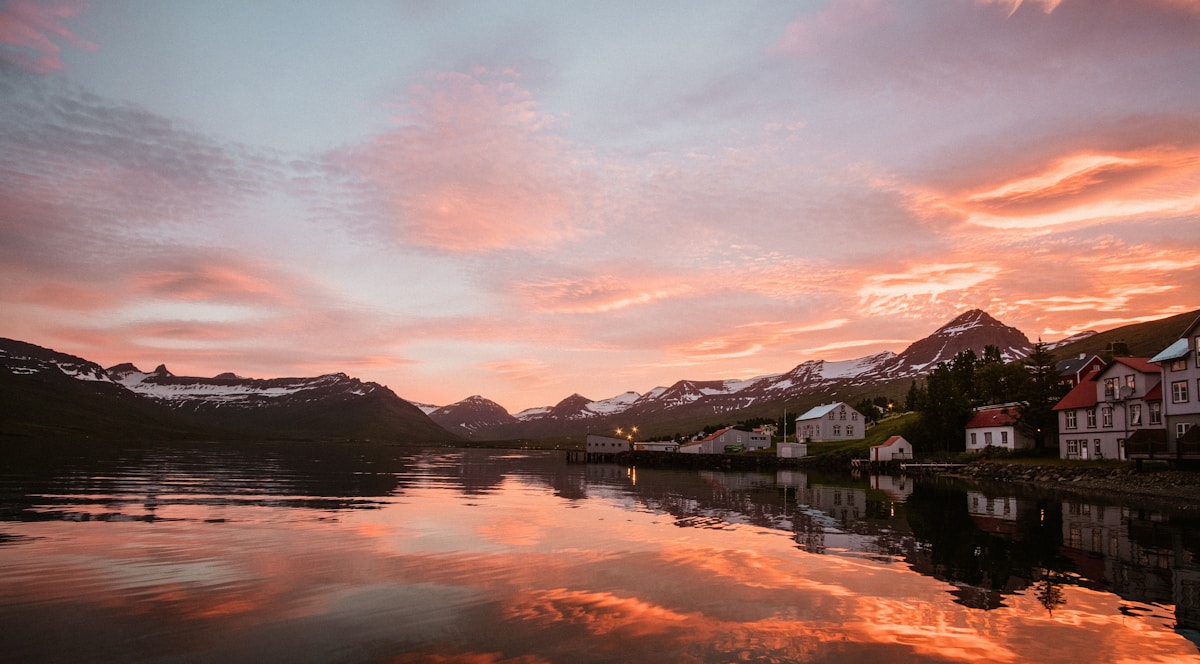 Lake with houses and mountains in background at Fáskrúðsfjörður, east Iceland
