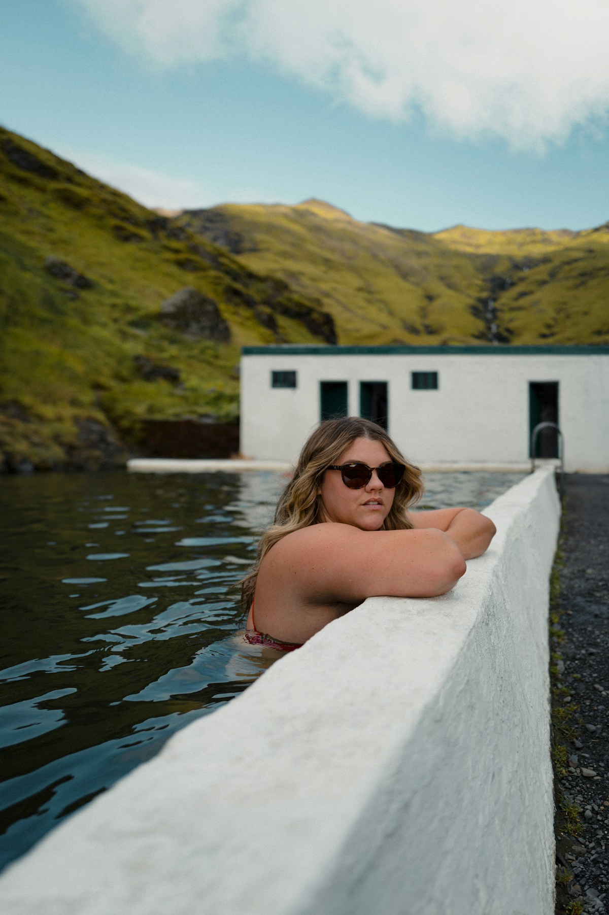 Bathers in a steaming natural hot spring surrounded by Icelandic hills