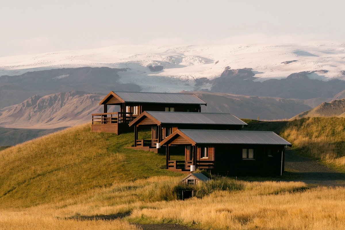 Group of cabins on a lush green hillside at Reynisfjara Beach, Iceland