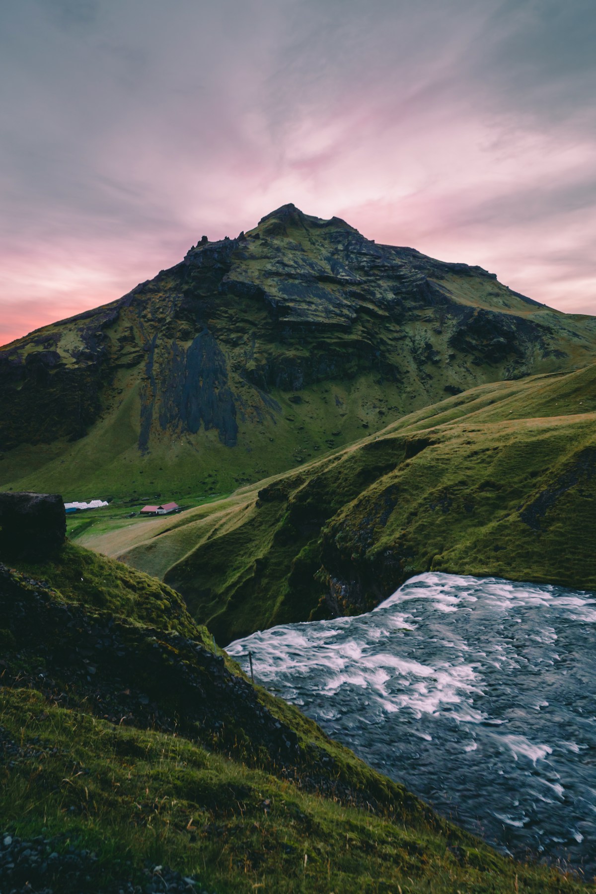 Twin waterfalls between green mountains near Skógafoss, Iceland