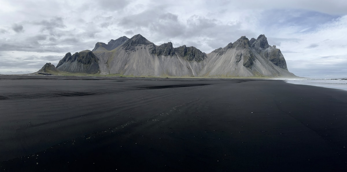 Flat black volcanic plain with Vestrahorn mountain in the background, Iceland