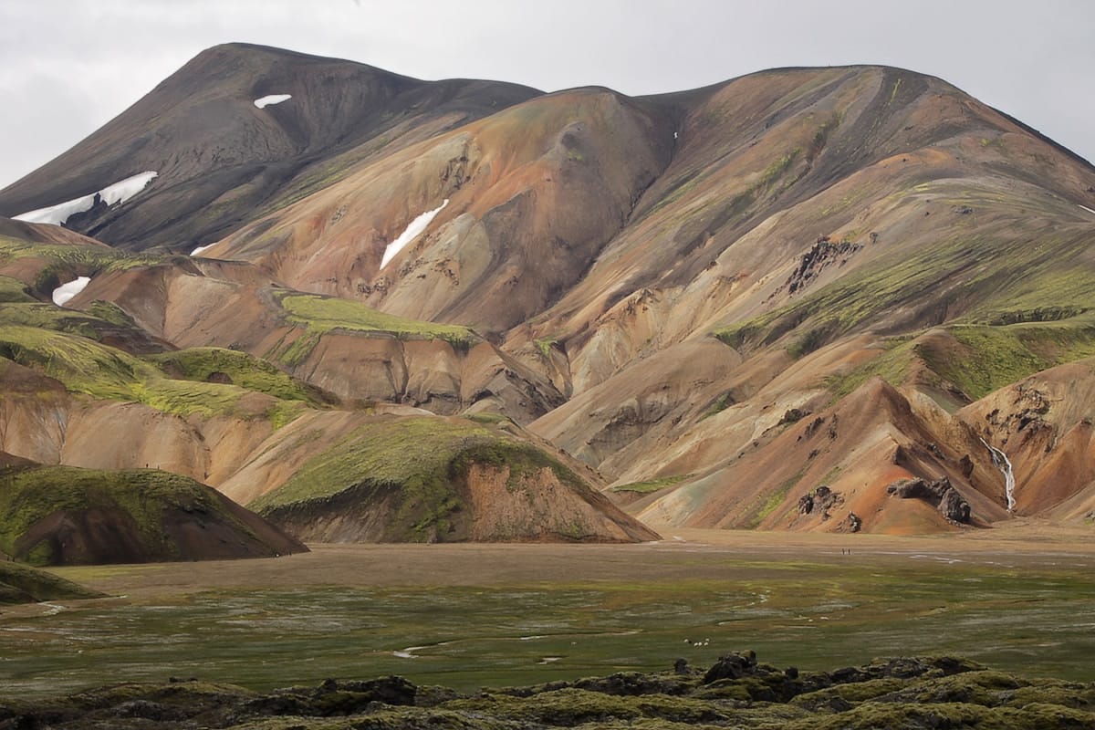 Colourful rhyolite mountains of Landmannalaugar rising above a flat highland plain, Iceland
