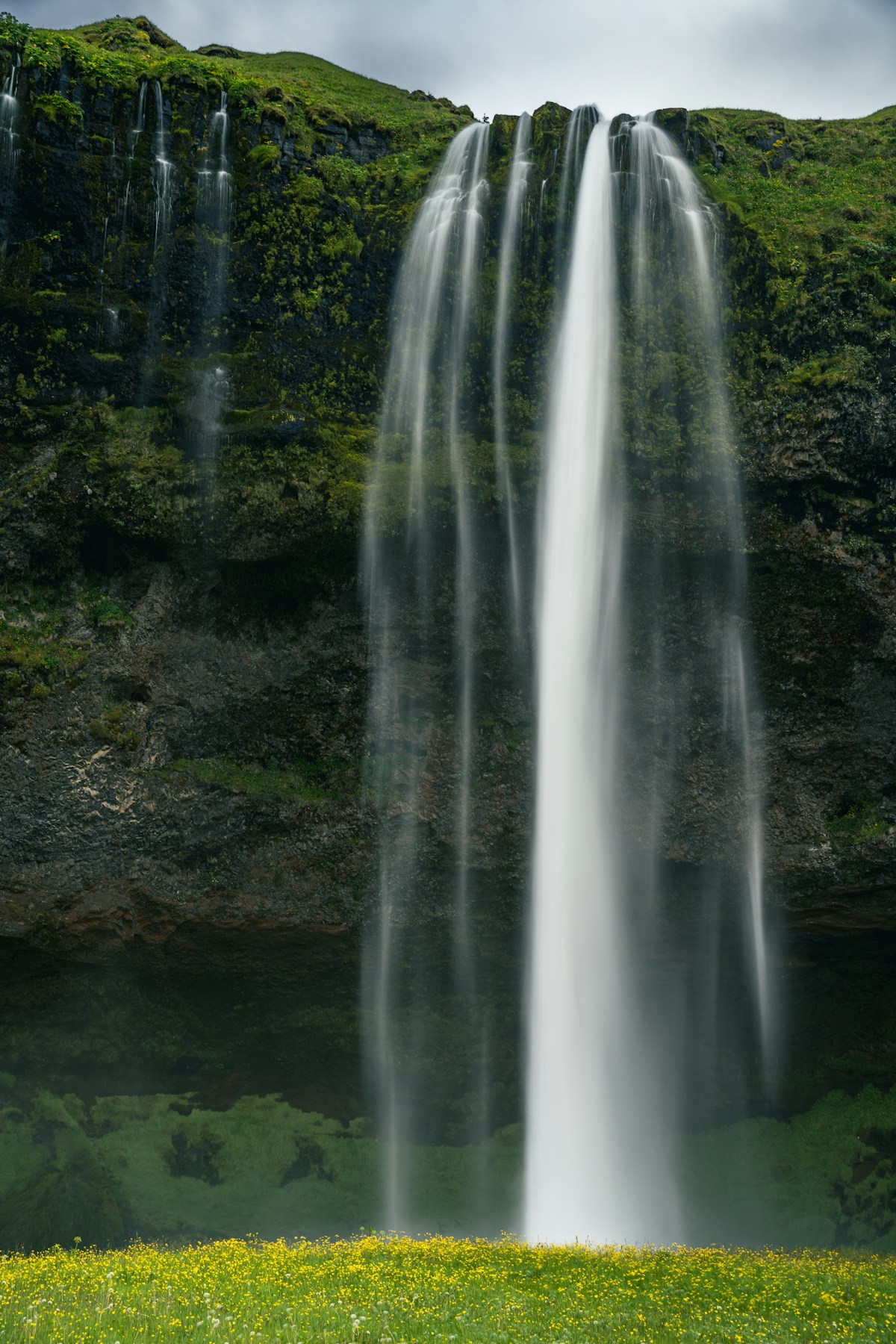 Man standing in front of Seljalandsfoss waterfall on the south coast of Iceland