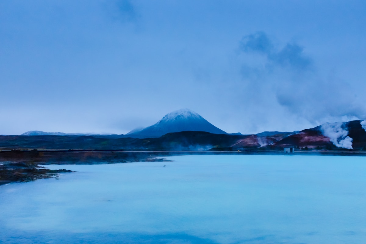 Mountain reflected in calm water at Mývatn Nature Baths, north Iceland