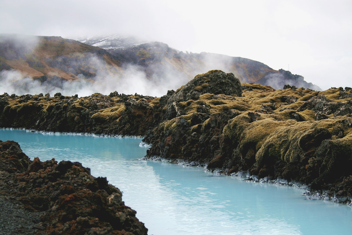 Geothermal hot spring with turquoise water and steam rising over lava fields, North Iceland