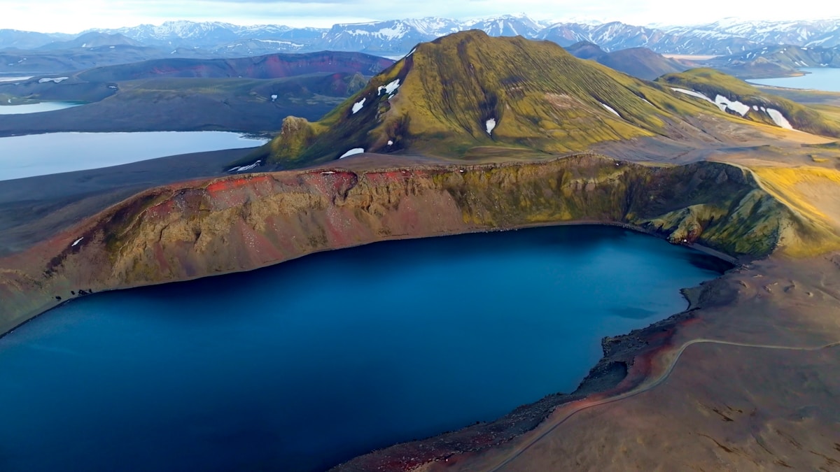 Vibrant blue volcanic lake surrounded by colourful rhyolite hills in the Iceland Highlands