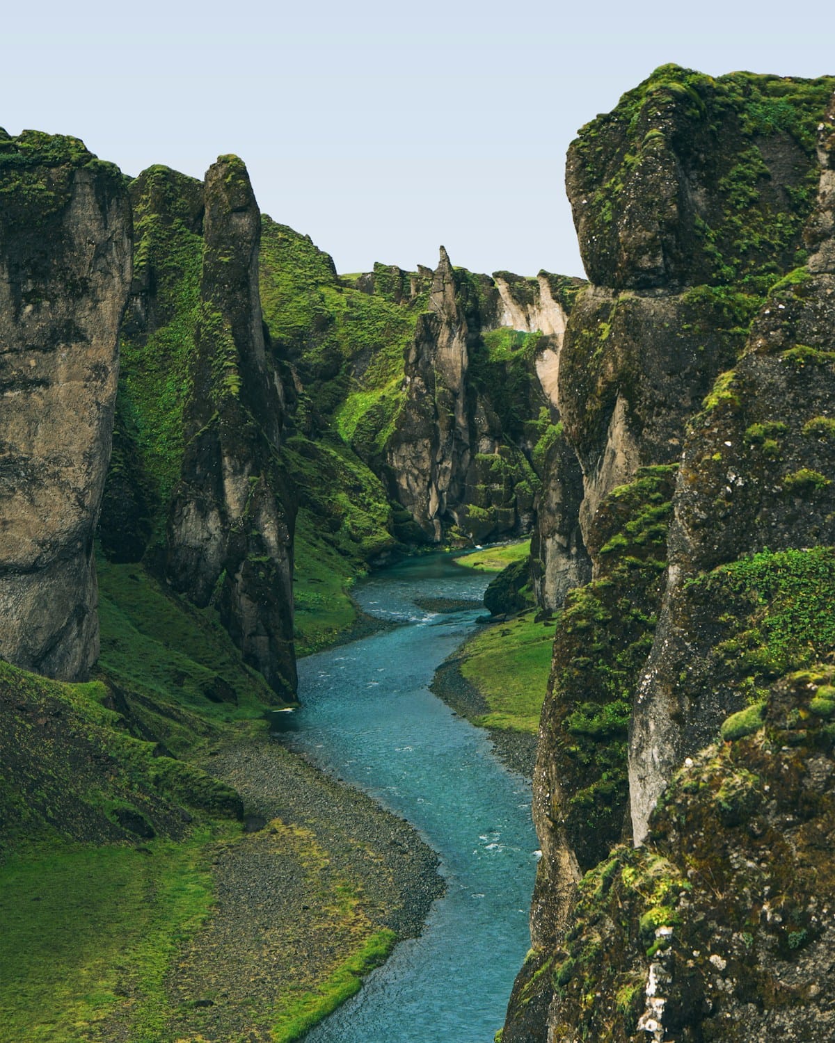 Turquoise river winding through a moss-covered canyon in Iceland highlands
